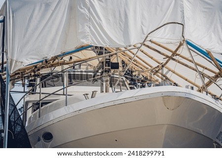Motor yacht moored for repairs and service in dry dock Royalty-Free Stock Photo #2418299791