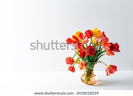 Big flowers bouquet of multicolored tulips in vintage glass vase on white color background with copy space. Business card. Invitation postcard. Place for greeting text. International holiday. Banner.