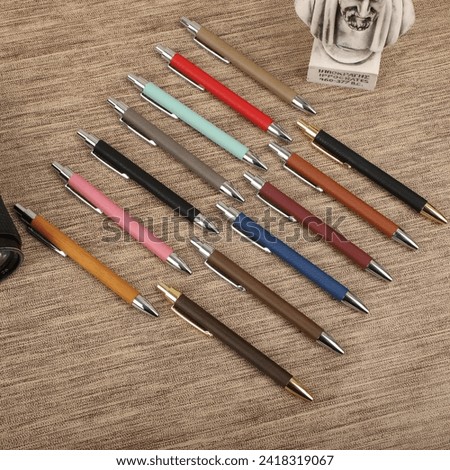 Colorful leather pen. Concept shot, top view, different colors pens. Blank space for text. Special background pen view.