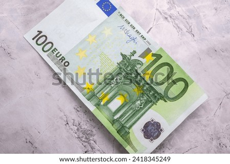 Close-up of 100 Euro banknotes isolated on a background. Close-up high quality photo of a 100 Euro bill lying on a marble background. Euro banknotes, inflation and price increases. Earning money.