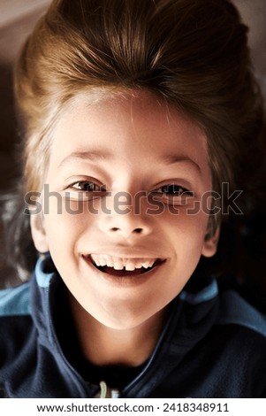 Young boy hanging upside down is smiling at camera. Royalty-Free Stock Photo #2418348911