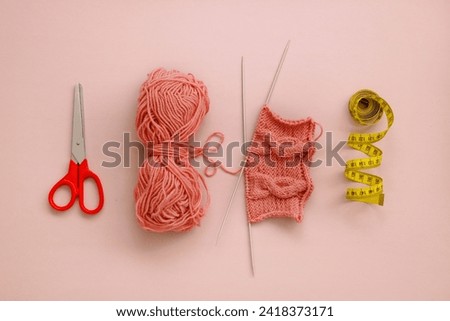 knitting accessories, scissors, skein of thread, knitting, centimeter laid out in a row.