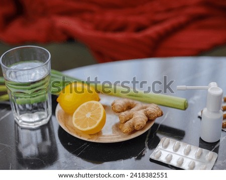 Ginger, lemon, onion and different drugs on table on background sick man. Alternative remedies and traditional pills to treat colds and flu. Natural medicine vs conventional medicine concept Royalty-Free Stock Photo #2418382551