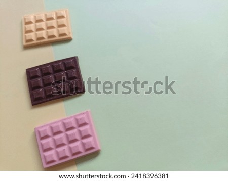Isolate dark, white and strawberry chocolate bar 
on colored Background