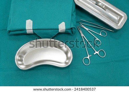 Surgical set and medical equipment on green surgical tray inside operating room.Sterile surgical instrument tool equipment for surgery.Infection control Royalty-Free Stock Photo #2418400537