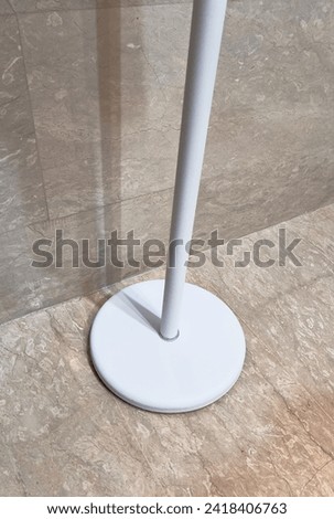 Picture of white pole stand based in a bathroom to place towel