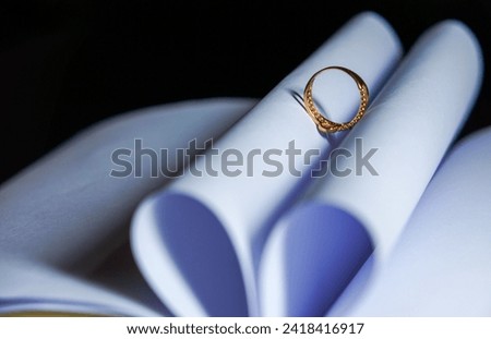 Selective focus on the ring on the open book results in a heart-shaped shadow. Romantic. A symbol of love.