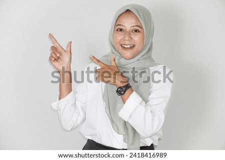 Portrait of a beautiful Asian woman pointing to an empty space