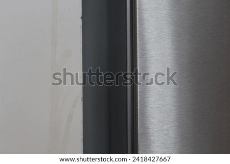 Artistic detail of the fridge and textured wall.