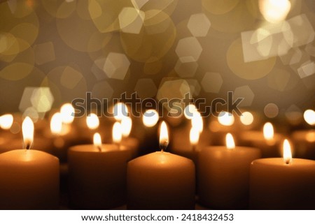 A candle burns on a dark background. Enlarged image of a candle in the dark. It burns and symbolizes grief and mourning. Background with copy space
