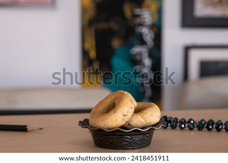 Arabic calligraphy with dates and sweets on wooden table