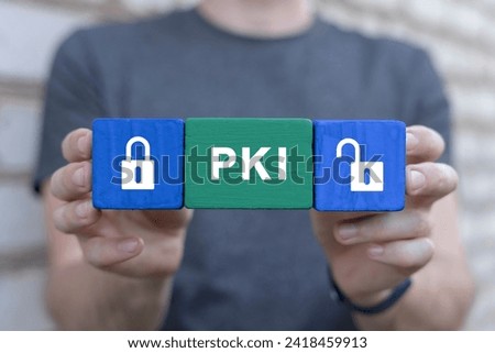 Man holding multi-colored blocks with lock and unlock padlocks icons sees abbreviation: PKI. Concept of Public Key Infrastructure ( PKI ) in business network encryption technology.