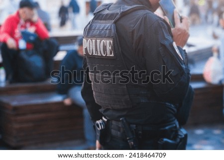 Police squad formation on duty maintain public order in the european city streets, group of policemen patrol  in body armor with "Police" logo on uniform, Europe, policeman in bulletproof vest
