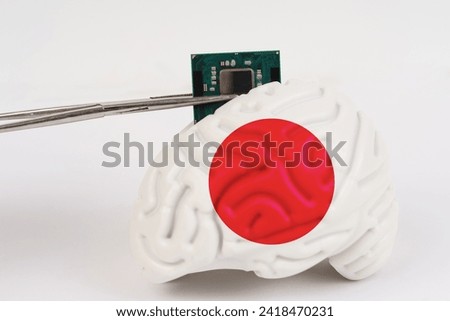 On a white background, a model of the brain with a picture of a flag - Japan, a microcircuit, a processor, is implanted into it. Close-up