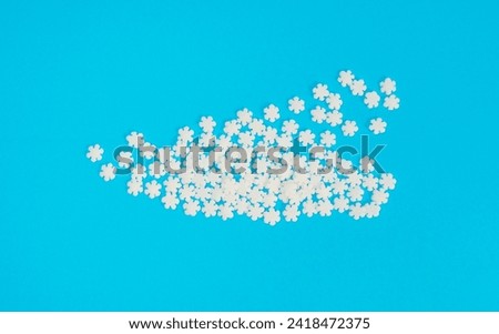 White Snowflake Sprinkles, Scattered Sugar Snow, Decorative Christmas Stars, Ice Xmas Decoration, Winter Confectionery Candy Sprinkle on Blue Background Top View