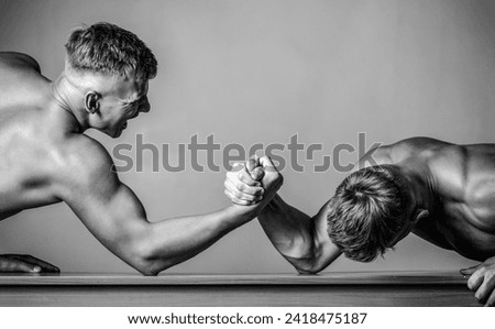 Arm wrestling. Two men arm wrestling. Hands or arms of man. Rivalry, closeup of male arm wrestling. Black and white.