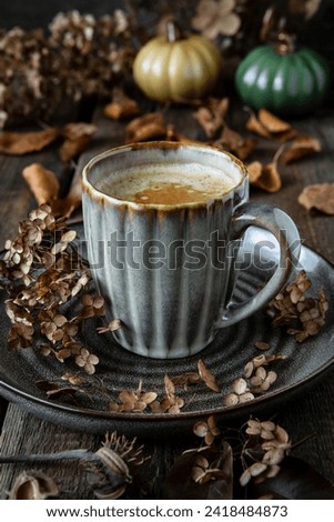 Ceramic  cup of coffee with  and autumn decorations on wooden   background. Selective focus with shallow depth of field