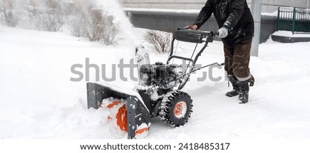 a man cleans snow with a snow plow outside. High quality photo