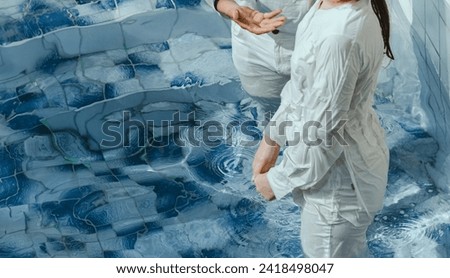 Pastor baptize a man in the name of Christ Royalty-Free Stock Photo #2418498047