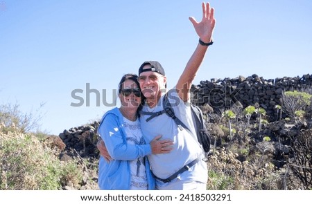 Cheerful senior bonding couple embracing enjoying together outdoors excursion in countryside. Healthy retirement lifestyle concept