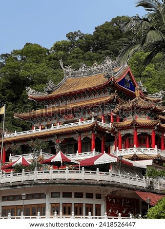Chih Nan or Zhinan taoist temple on the slopes of Houshan mountain in Wenshan District of Taipei, Taiwan. Bright sunny day, clear blue sky, green trees surrounding the temple. Royalty-Free Stock Photo #2418526447