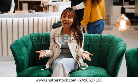 POV of asian woman waving at videocall connection, talking to her friends after arriving at hotel. Tourist catching up with people on online videoconference, waiting in lounge area. Tripod shot. Royalty-Free Stock Photo #2418527163