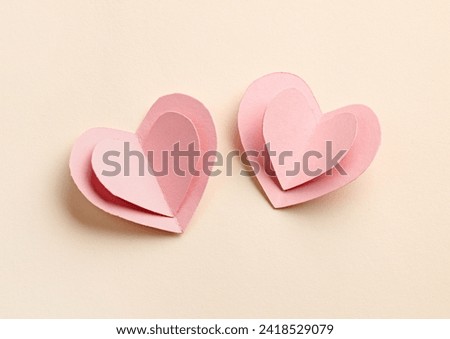 decorative pink paper hearts on beige background, top view