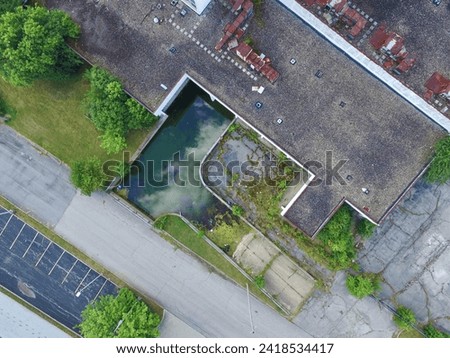 Aerial Top Down View of Neglected Urban Building and Overgrown Lot Royalty-Free Stock Photo #2418534417