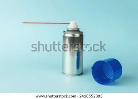 An aerosol can with lubricant on a blue background. A means for lubricating mechanisms. Royalty-Free Stock Photo #2418552883