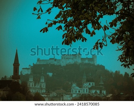 The photo captures the enchanting vistas of Salzburg, Austria, with its charming architecture. Iconic Hohensalzburg Fortress stands proudly on the hill, overlooking the picturesque old town