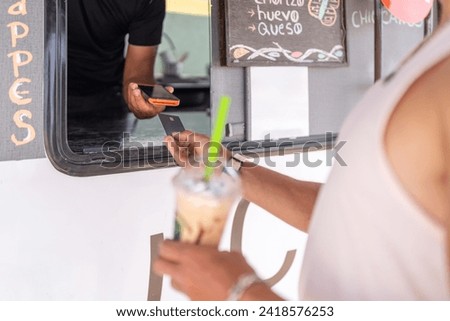 Close-up photo of a commercial interaction of a food truck offering contact less payment to a client