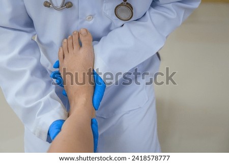 Close-up picture of an orthopedic doctor wearing medical gloves An orthopedic doctor examines a patient's ankle to analyze the cause of ankle osteoarthritis in his office at the hospital.