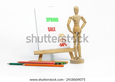 Mannequin drawing a SALE on easel; isolated on white background; Business or sales promotion concept