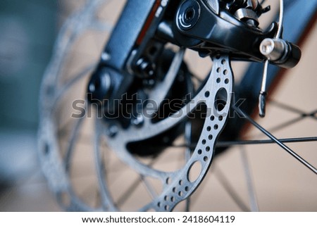 Part of the bicycle's braking system. Grey metal brake disc and brake pads on road bike, close up. Royalty-Free Stock Photo #2418604119