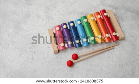 Rainbow colored metal toy xylophone isolated on grey background