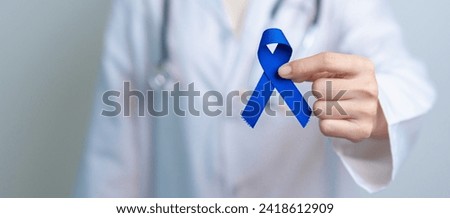March Colorectal Cancer Awareness month, doctor with dark Blue Ribbon for supporting people living and illness. Healthcare, hope and World cancer day concept Royalty-Free Stock Photo #2418612909