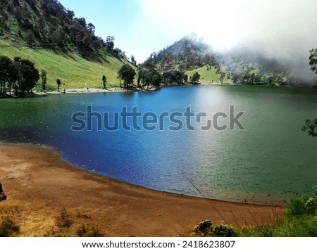 Ranu Kumbolo Lake with views of the mountain slopes and beautiful green water of Mount Semeru, Indonesia