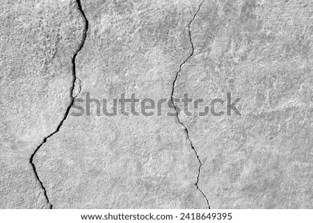The wall of an old building with winding, deep cracks. Copy space. Black and white photo. Selective focus. Royalty-Free Stock Photo #2418649395