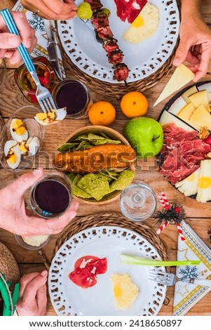 Top view of christmas celebration wooden table full of food decorations and people having fun together - family tradition and friends having lunch or dinner for xmas at home or restaurant