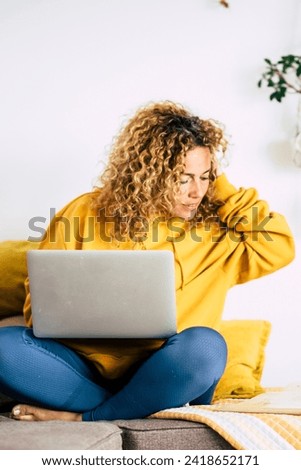 Adult blonde woman at home work with computer laptop and internet connection -concept of technology activity and smart job with modern people - lockdown quarantine for covid-19 Royalty-Free Stock Photo #2418652171