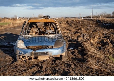 A burned car wreck near to highway Royalty-Free Stock Photo #2418661803
