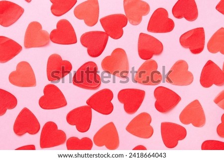 Red paper hearts on pink Valentine's Day background