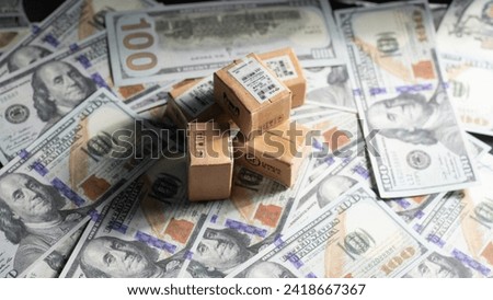 Boxes on dollar bills.Boxes in a trolley on a laptop keyboard. online shopping is electronic commerce that allows consumers to directly buy goods from a seller over the internet.