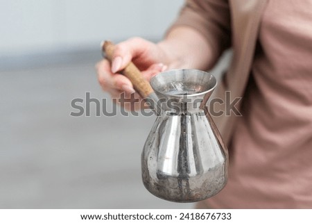 Woman holding copper turkish coffee pot on white background, closeup