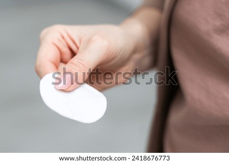Female hand holding cotten pad. Beauty, spa, body care. Make-up removal Royalty-Free Stock Photo #2418676773