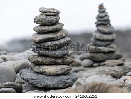 Close up of two towers of pebbles stacked up on a pebble beach