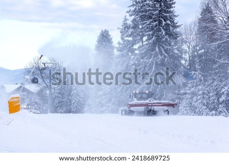 Snow groomer snowcat ratrack machine preparing ski road slope for alpine skiing, winter resort Bansko, Bulgaria