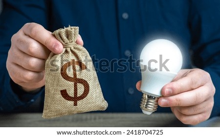 Dollar money bag and burning idea light bulb in the hands of a man. Reduce carbon footprint Education and skills. Investment in an idea. Offering financial incentives to enhancing energy efficiency.