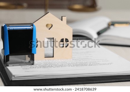Notary contract. Figure of house, documents and stamp on white table