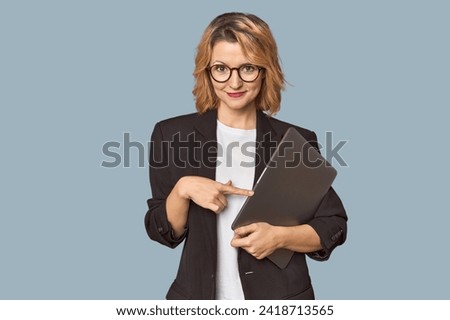 Caucasian middle-aged businesswoman with laptop in studio Royalty-Free Stock Photo #2418713565